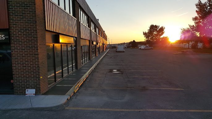 Finished commercial sidewalk beside a brick building at sunset